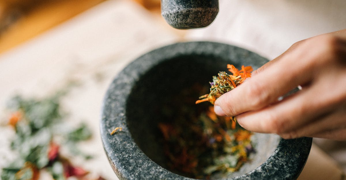 What kind of mortar and pestle is most food safe? - Person Holding Gray Mortar and Pestle