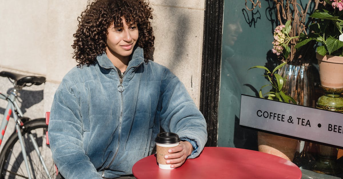 What kind of tea do you boil for 45minutes? - Smiling ethnic woman with coffee to go in street cafe What kind of tea do you boil for 45minutes? - Smiling ethnic woman with coffee to go in street cafe