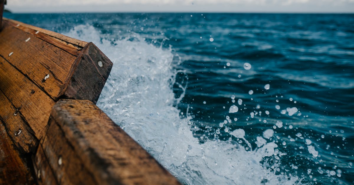 What kind of vessel is suitable for storing and aging eggnog? - Detail of shabby wooden boat sailing in blue sea and splashing water in summer