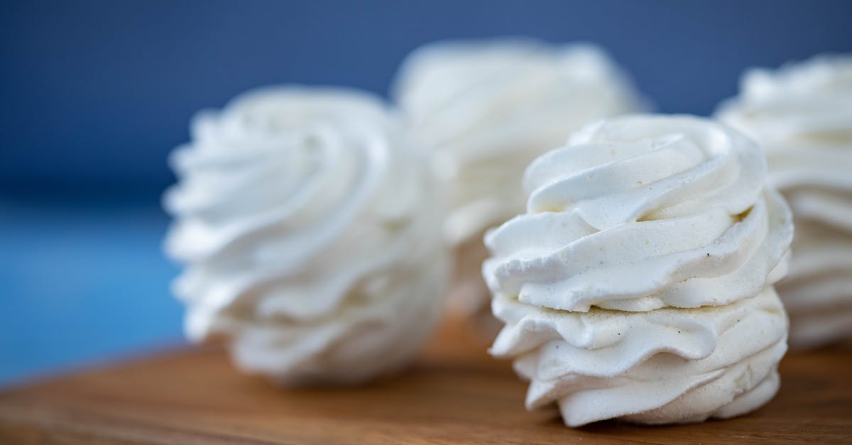 What makes a souffle rise? - Sweet zephyrs placed on wooden board against blurred background What makes a souffle rise? - Sweet zephyrs placed on wooden board against blurred background
