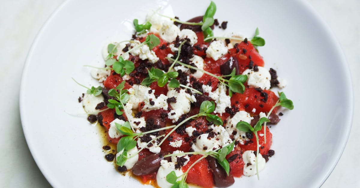 what makes red tomato sauce turn orange in colour? - High angle of delicious vegetarian salad with fresh basil and beans with red pepper and eggs with sauce on white plate at table in restaurant