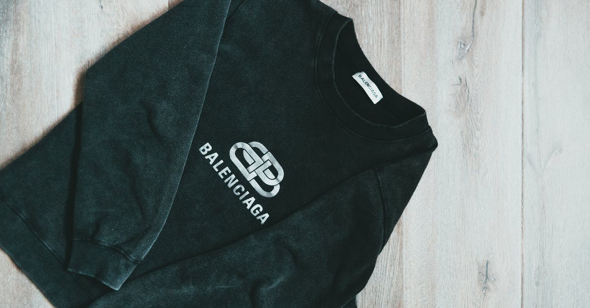 What makes store brand mayo white? - Top view of fashionable black soft sweatshirt with white logo placed on wooden surface
