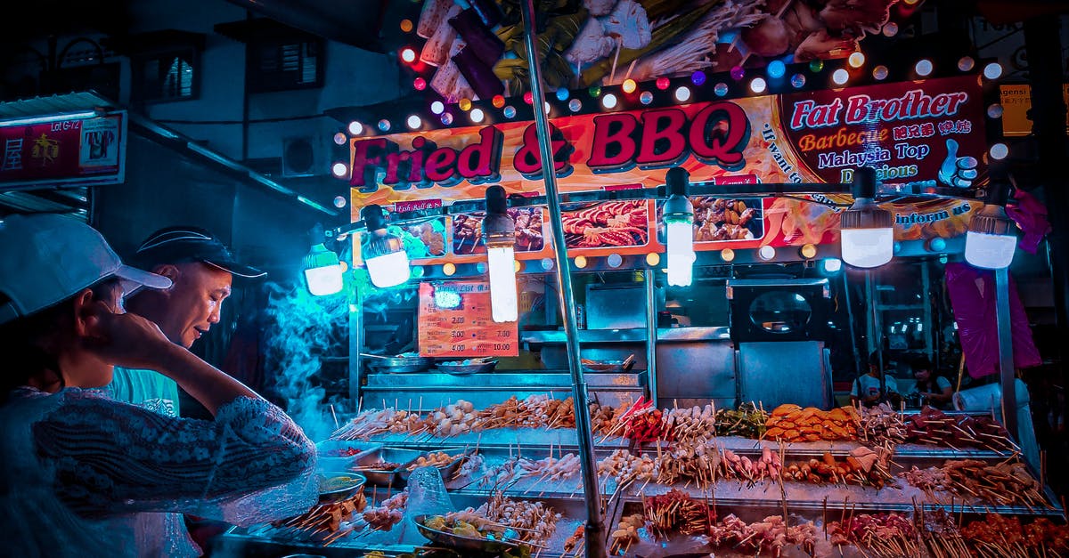 What methods are there of getting fresh local meat & produce? - Customer choosing raw kebab in street stall at night What methods are there of getting fresh local meat & produce? - Customer choosing raw kebab in street stall at night