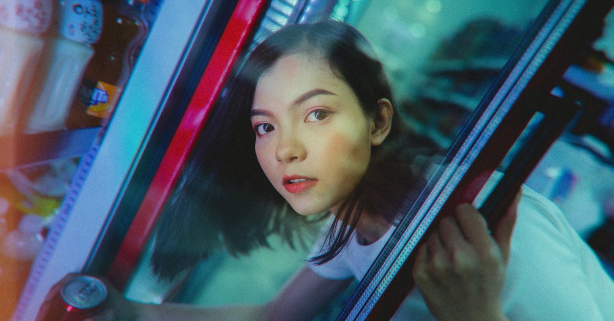 What part or kind of geoduck gives crunchy slender slices? - Calm ethnic woman taking refreshing drink from refrigerator in shop What part or kind of geoduck gives crunchy slender slices? - Calm ethnic woman taking refreshing drink from refrigerator in shop