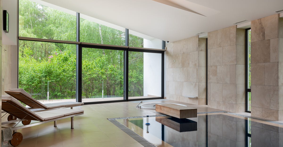 What property makes a liquid soapy/bubbly? - Interior of contemporary large apartment with deck chairs and swimming pool with clean water in daytime What property makes a liquid soapy/bubbly? - Interior of contemporary large apartment with deck chairs and swimming pool with clean water in daytime
