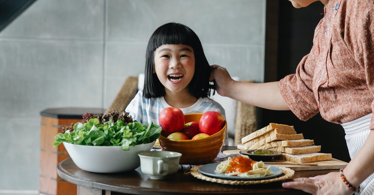 What should I look for when buying a pasta roller? - Crop unrecognizable female in apron standing near table and caressing child while having breakfast together at home What should I look for when buying a pasta roller? - Crop unrecognizable female in apron standing near table and caressing child while having breakfast together at home