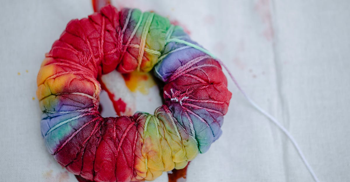 What technique is used to remove the bubbles and big hole from swiss rolls? - Folded fabric with colorful paints on white background What technique is used to remove the bubbles and big hole from swiss rolls? - Folded fabric with colorful paints on white background