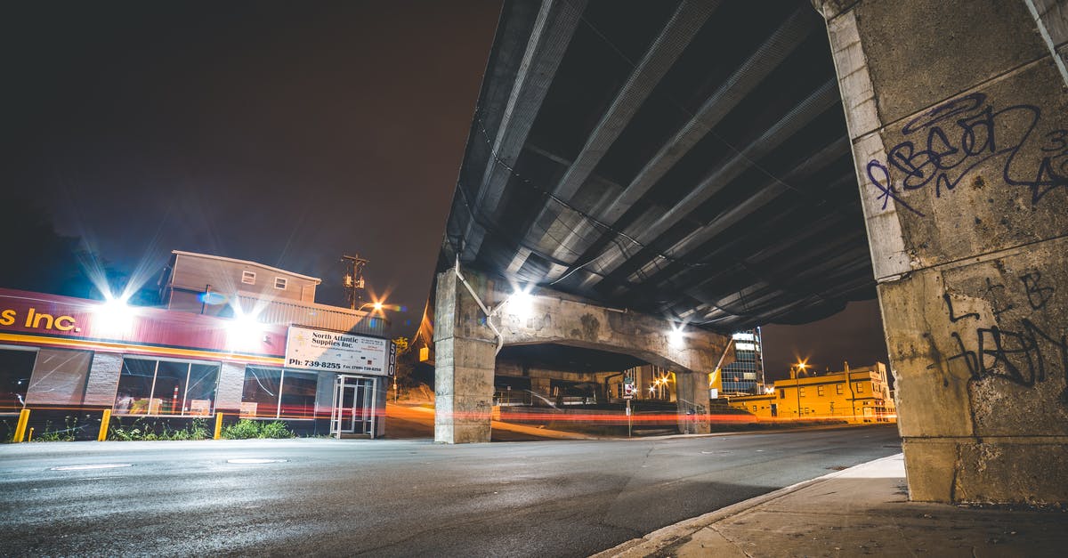What the gluten look like when kneading for long time on a texture basis - Illuminated empty asphalt road placed under old bridge with graffiti at night time