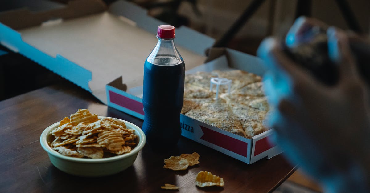 What to do with soggy mushy potato chips? - Crop person at table with potato chips and cola What to do with soggy mushy potato chips? - Crop person at table with potato chips and cola