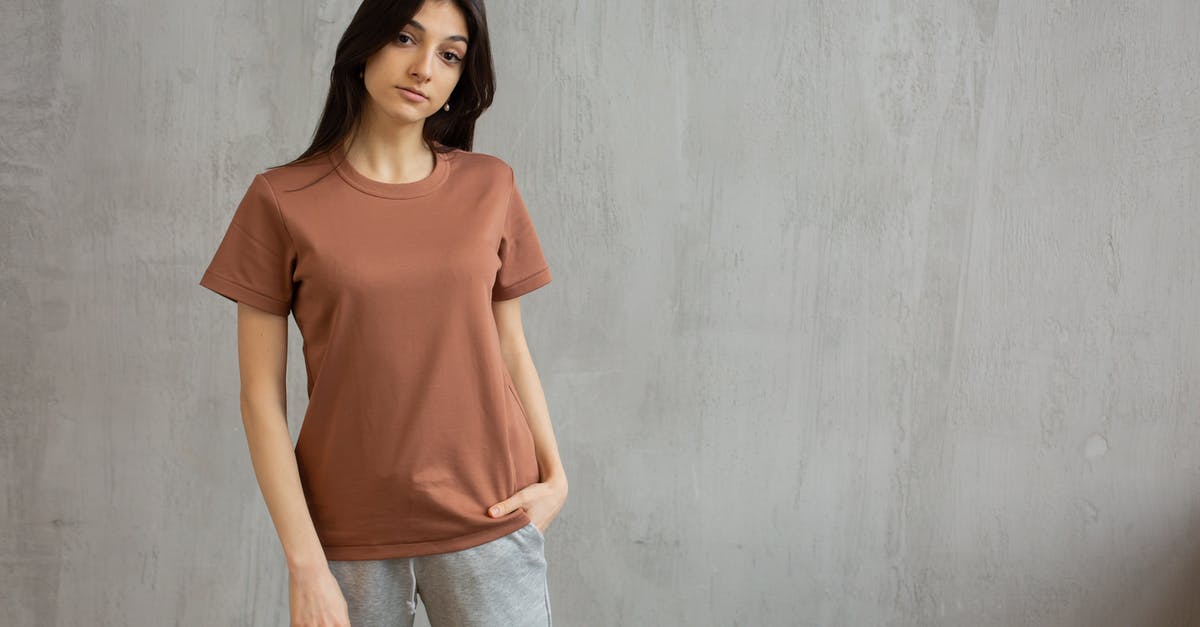What to look for in a Stand Mixer? - Serious female with long hair wearing t shirt and sweatpants standing against gray wall and looking at camera What to look for in a Stand Mixer? - Serious female with long hair wearing t shirt and sweatpants standing against gray wall and looking at camera