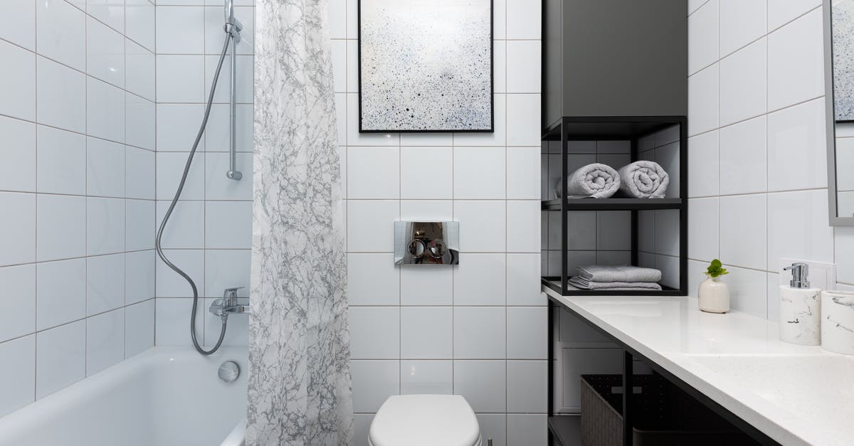 What to put underneath a polycarbonate sous vide bath container? - Interior of light bathroom with toilet near bathtub with shower and curtain near counter with shelves with towels and containers and decorative objects near white tile What to put underneath a polycarbonate sous vide bath container? - Interior of light bathroom with toilet near bathtub with shower and curtain near counter with shelves with towels and containers and decorative objects near white tile