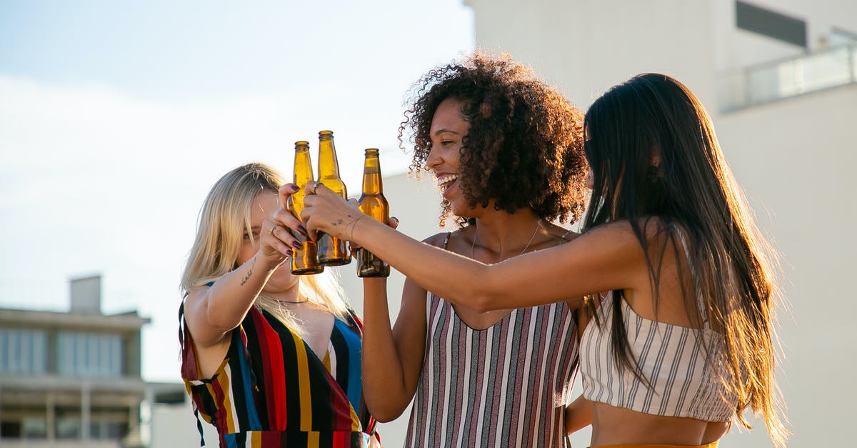 What type of beer is best for beer battered fish? - Joyful women clinking beer bottles on rooftop What type of beer is best for beer battered fish? - Joyful women clinking beer bottles on rooftop