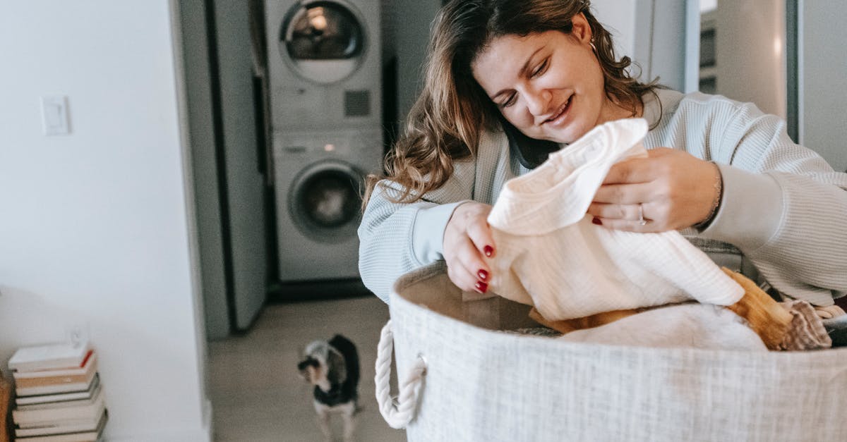 What would you use to wash pretzel hot dog buns? - Positive woman with clean clothes speaking on smartphone
