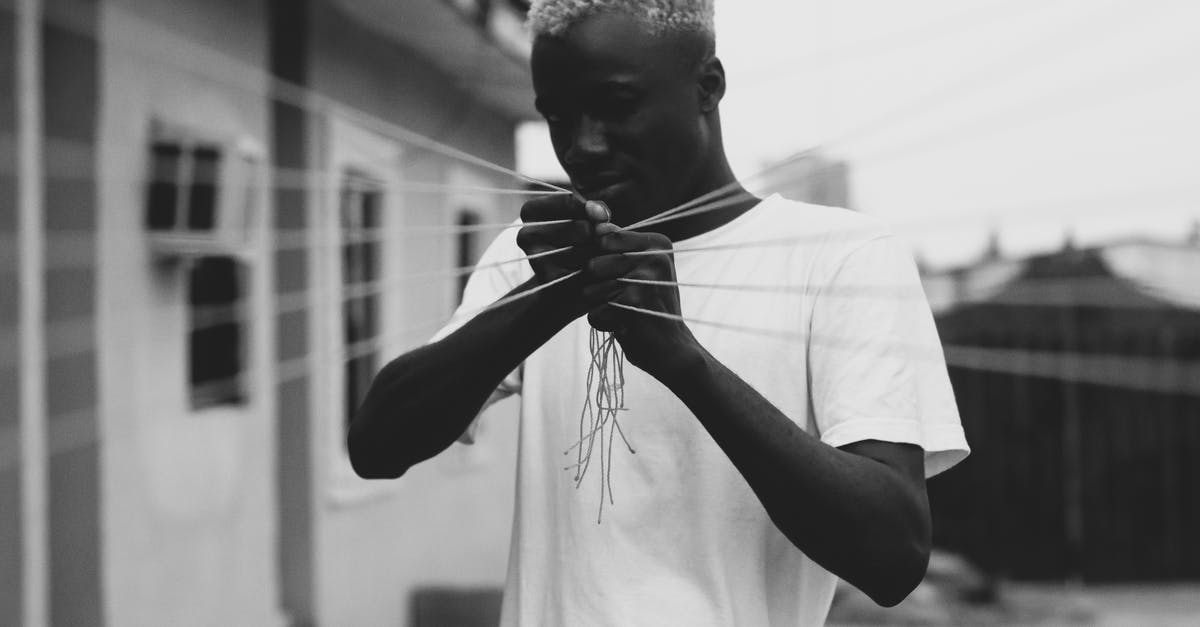 When I pull the trigger on my cream whipper, it won't stop, even when released - Concentrated young black man pulling elastic threads on street When I pull the trigger on my cream whipper, it won't stop, even when released - Concentrated young black man pulling elastic threads on street