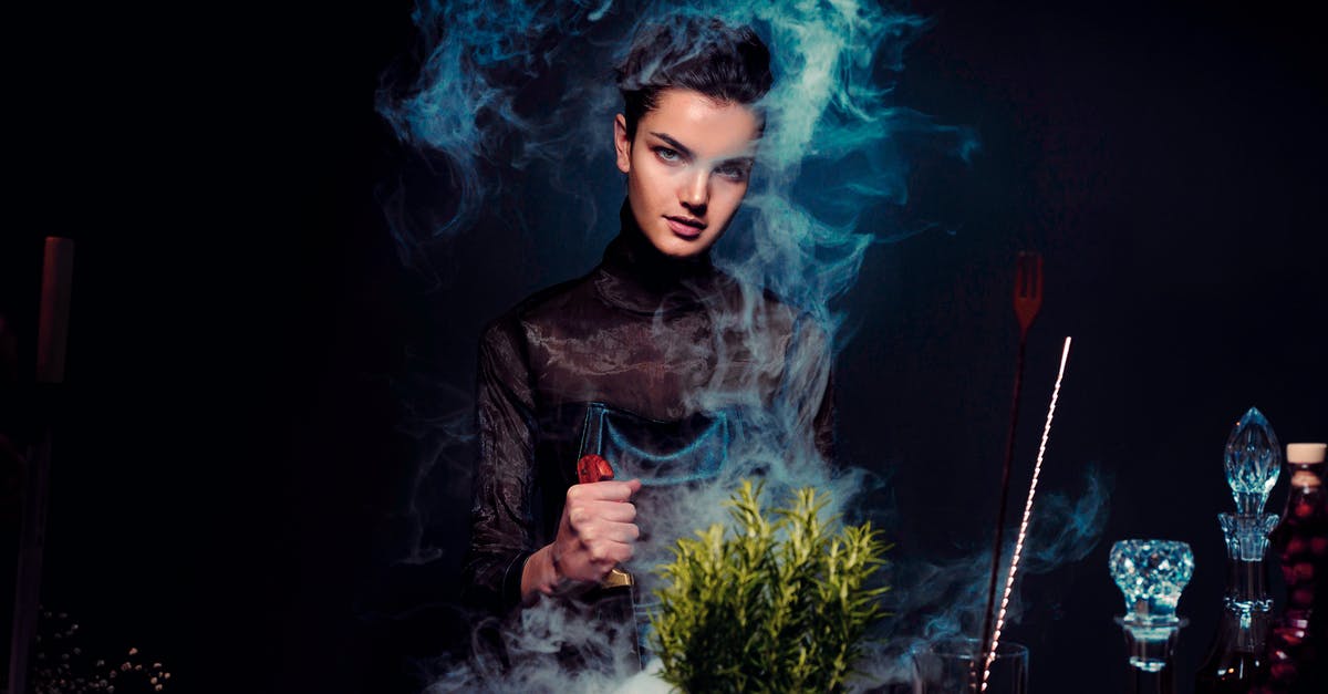When is black burned? - Graceful young female alchemist with knife in hand in black outfit preparing potion from various herbs among smoke in dark room When is black burned? - Graceful young female alchemist with knife in hand in black outfit preparing potion from various herbs among smoke in dark room