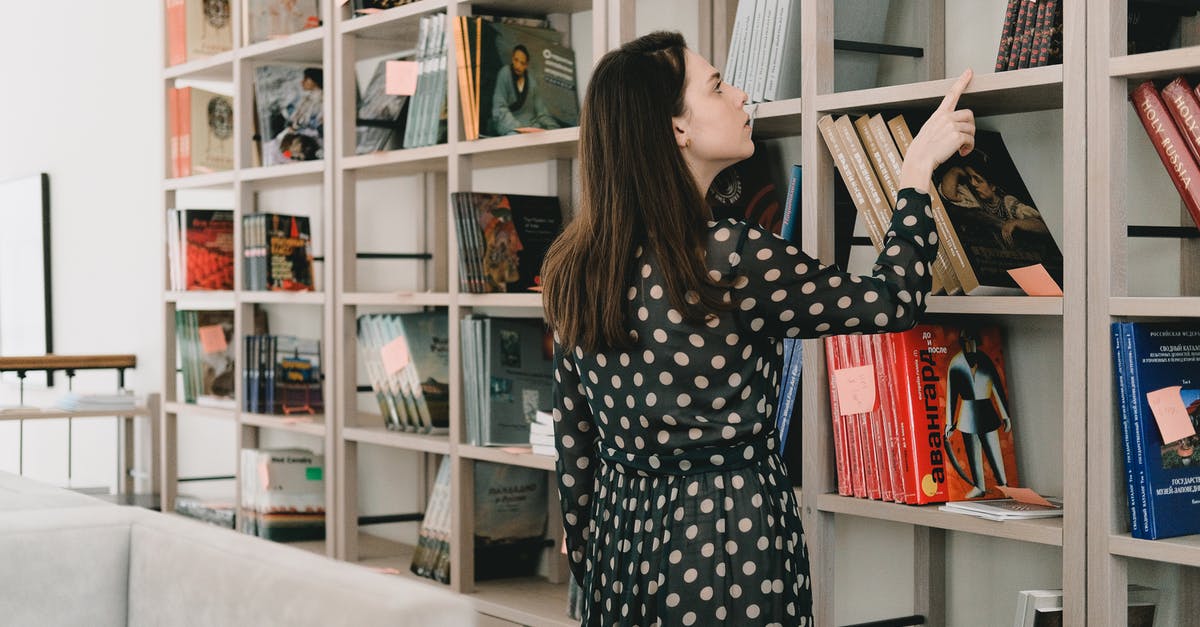 When is the right time to pick blueberries? - Young woman choosing book from bookshelf When is the right time to pick blueberries? - Young woman choosing book from bookshelf