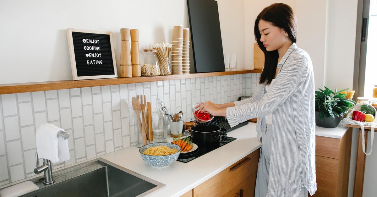 When to add vegetables in slow cooker? - Asian woman cooking near stove When to add vegetables in slow cooker? - Asian woman cooking near stove
