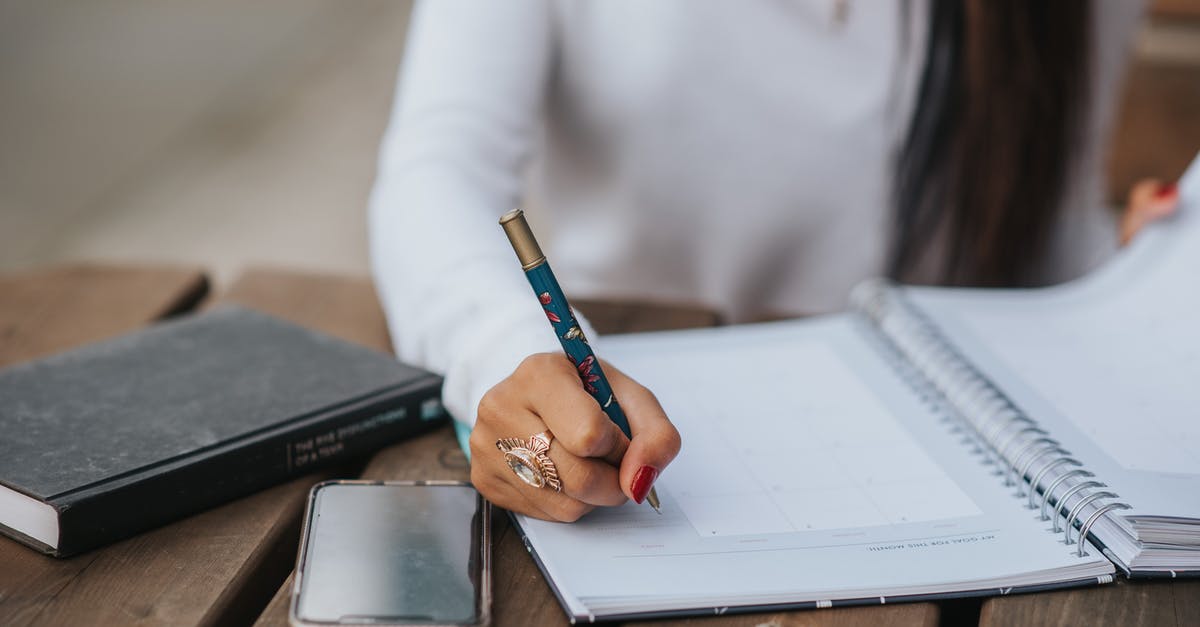 Where can I find an extremely slim wooden stirring spoon? - Crop office employee taking notes in notebook at table Where can I find an extremely slim wooden stirring spoon? - Crop office employee taking notes in notebook at table