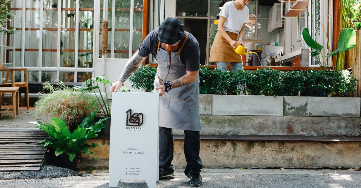 Where can I get local grains in bulk? - Couple of coworkers in aprons and casual clothes watering plants and putting signboard near cafeteria in daytime Where can I get local grains in bulk? - Couple of coworkers in aprons and casual clothes watering plants and putting signboard near cafeteria in daytime