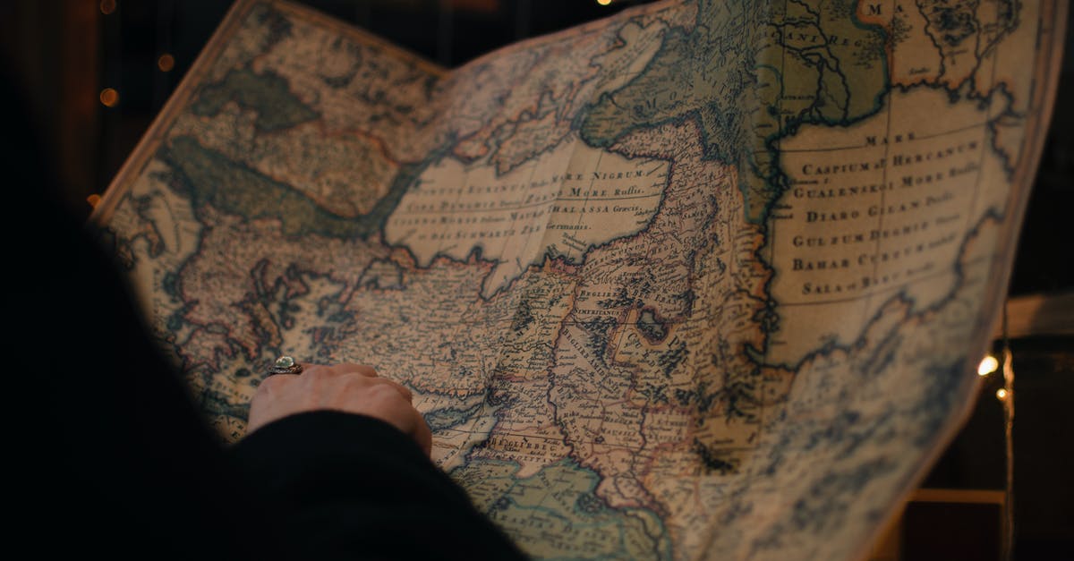 Where to find a large individual brownie pan? - From behind anonymous person examining antique world map printed on large paper in blue colors in dark room Where to find a large individual brownie pan? - From behind anonymous person examining antique world map printed on large paper in blue colors in dark room