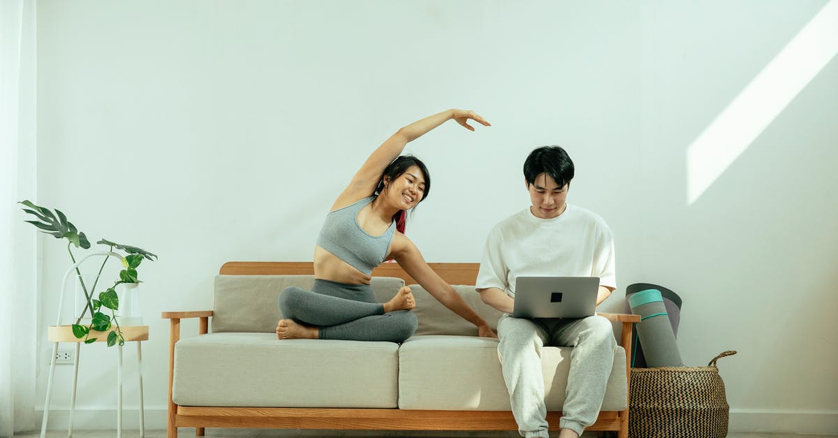 Which cooking device allows flexible temperature programming? - Full body of Asian male using laptop while happy female stretching body on sofa in light living room Which cooking device allows flexible temperature programming? - Full body of Asian male using laptop while happy female stretching body on sofa in light living room