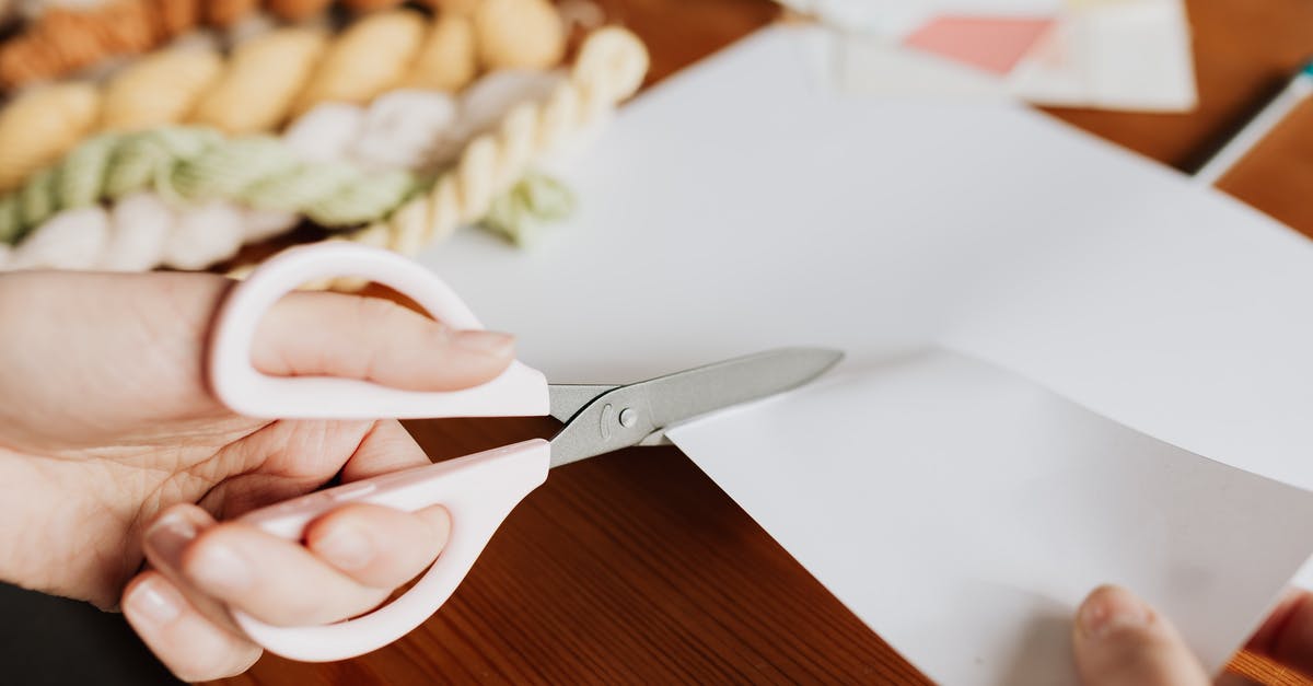 Which cut makes cheapest goulash? - Crop young woman cutting paper sheet on wooden table Which cut makes cheapest goulash? - Crop young woman cutting paper sheet on wooden table