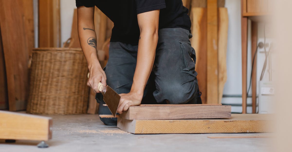 Which cut makes cheapest goulash? - Crop anonymous male with tattoo sawing piece of timber detail with planer in workshop Which cut makes cheapest goulash? - Crop anonymous male with tattoo sawing piece of timber detail with planer in workshop
