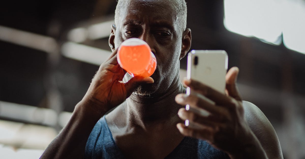 Which drinks fit to a Thai Dish? [closed] - Man in Blue Tank Top Using Cellphone While Drinking
