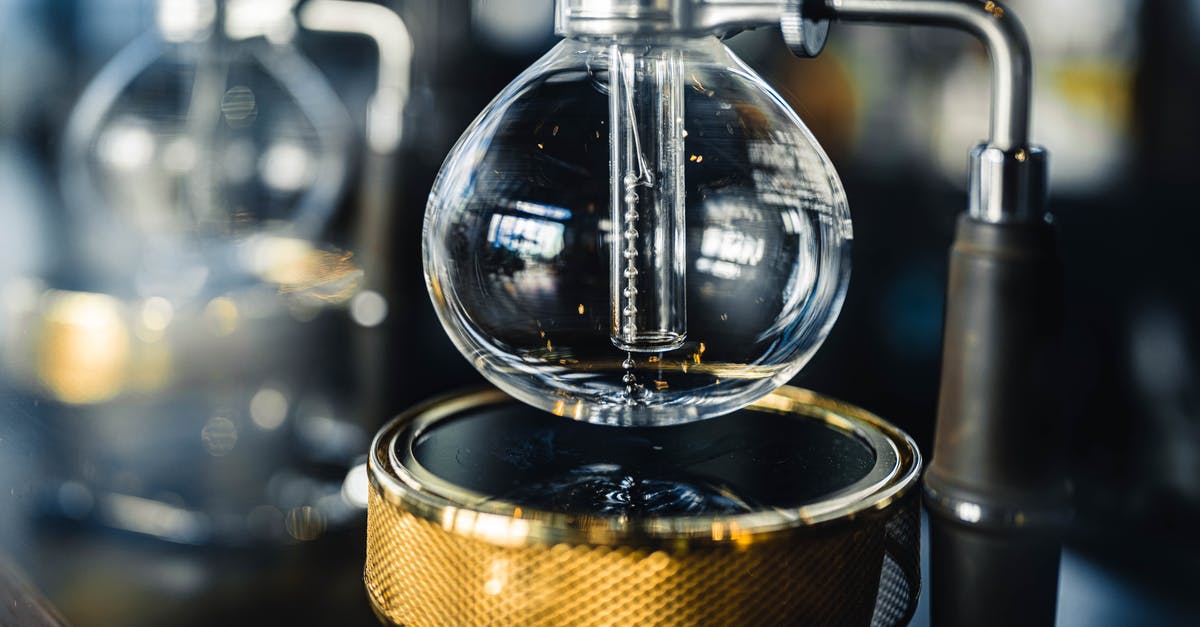Which part of the coffee brew is best? - Professional vacuum coffeemaker with glass bottom bowl and burner placed on table in modern coffee house with equipment on blurred background Which part of the coffee brew is best? - Professional vacuum coffeemaker with glass bottom bowl and burner placed on table in modern coffee house with equipment on blurred background