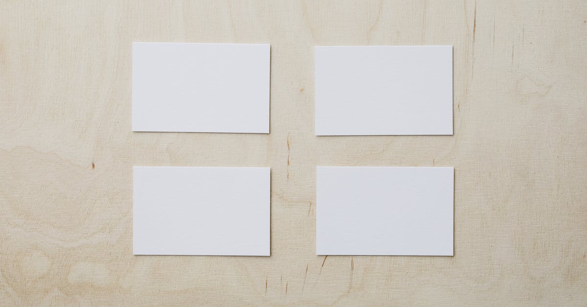Which product for white chapatis? - Overhead view of clean white mockup greeting cards placed on light brown wooden desk Which product for white chapatis? - Overhead view of clean white mockup greeting cards placed on light brown wooden desk