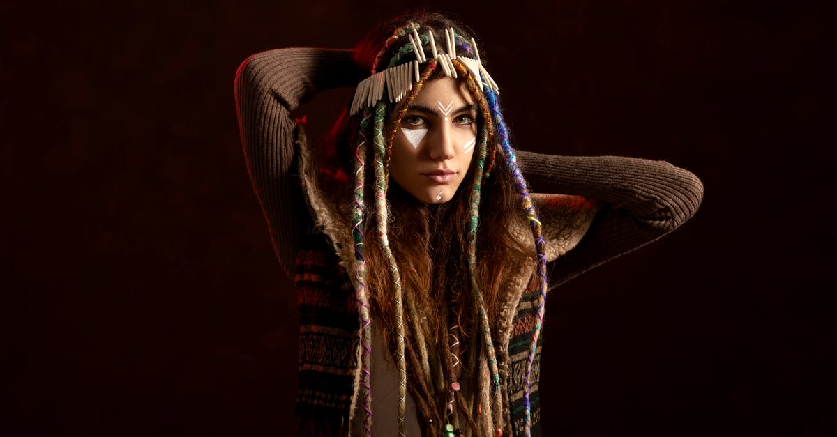 Which spice gives brown colour to Indian curry? - Young ethnic woman with threads on dreadlocks and hands behind head looking at camera on black background Which spice gives brown colour to Indian curry? - Young ethnic woman with threads on dreadlocks and hands behind head looking at camera on black background