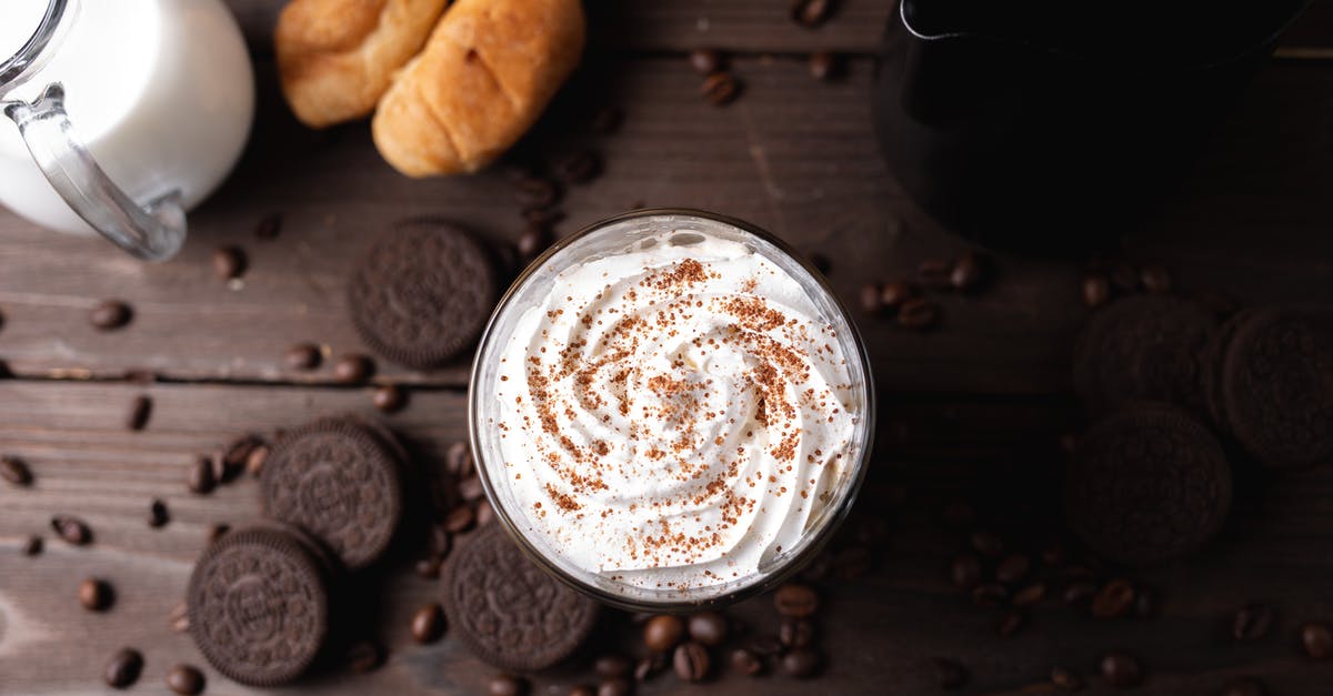 Whipped cream from milk powder - Whipped cream drink on table amidst coffee beans and cookies Whipped cream from milk powder - Whipped cream drink on table amidst coffee beans and cookies