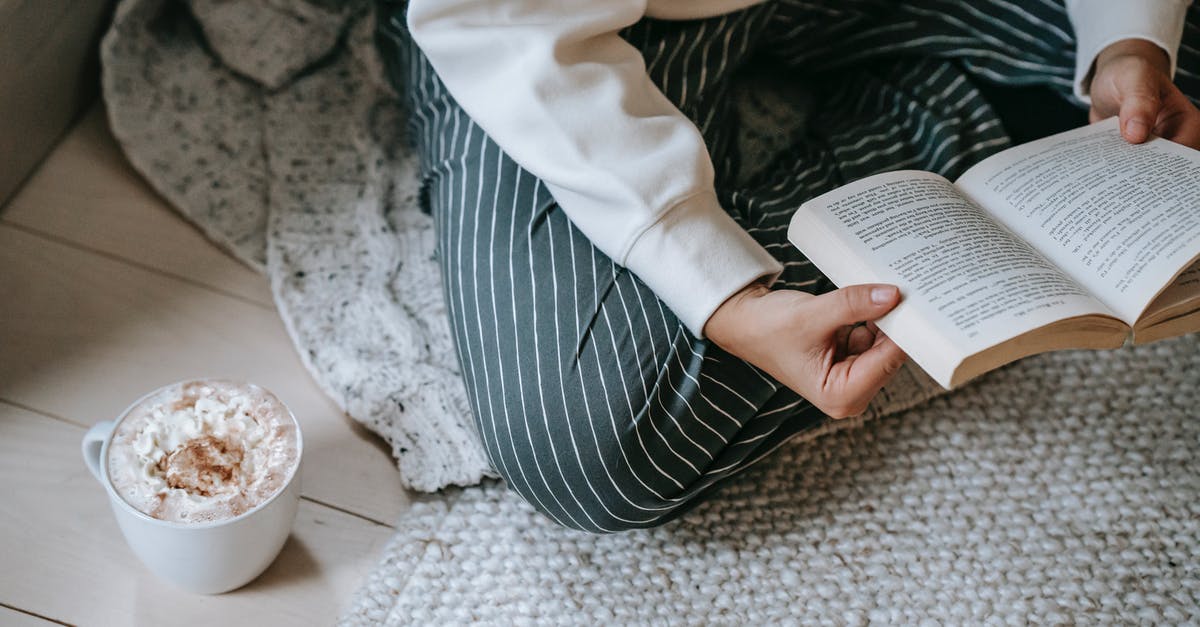Whipped cream running permanently from siphon - Female reading book while drinking coffee with whipped cream Whipped cream running permanently from siphon - Female reading book while drinking coffee with whipped cream