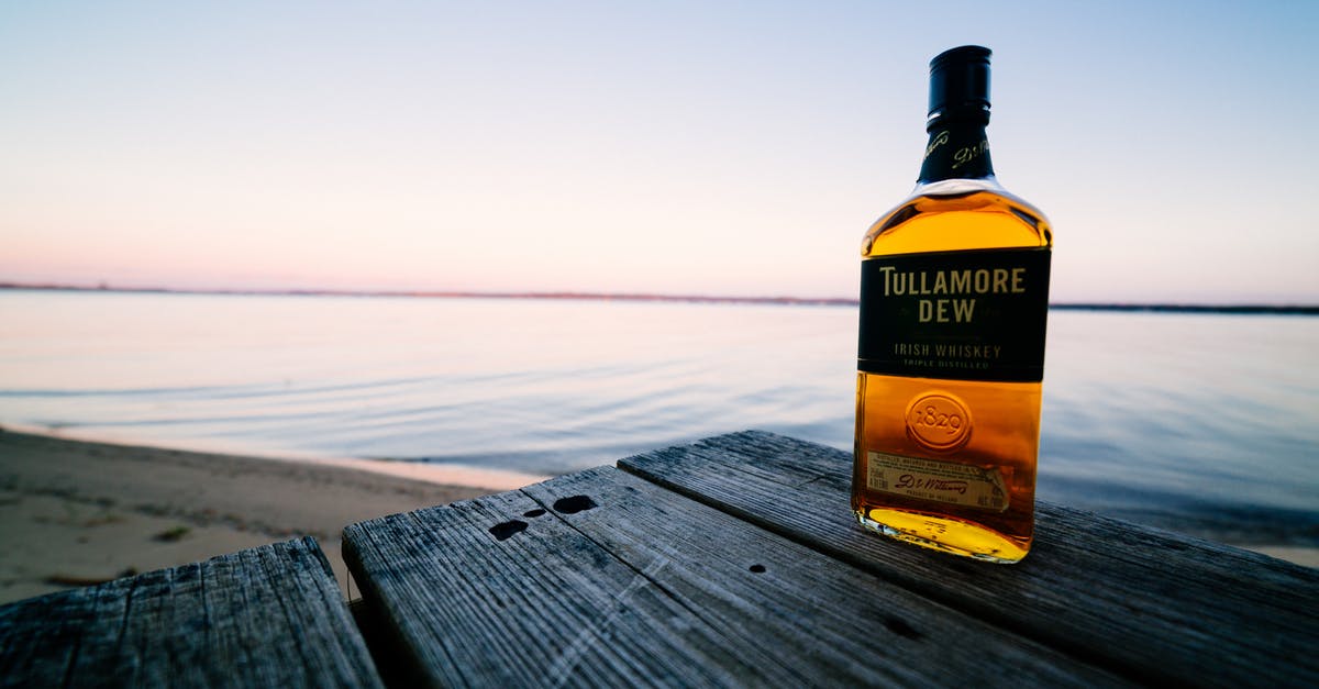 Whiskey and Water - Bottle of strong elite alcohol near ocean under sky Whiskey and Water - Bottle of strong elite alcohol near ocean under sky