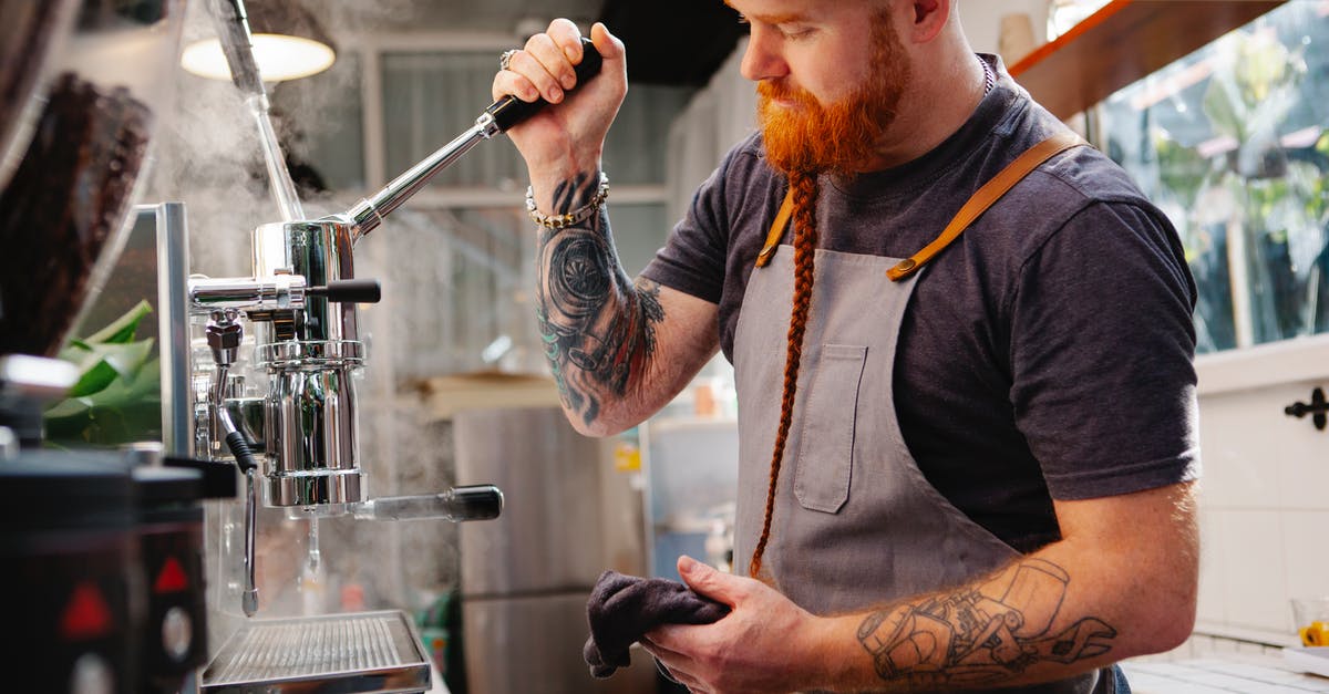 Why are my pots creating a vapor like steam from the inside? - Side view of tattooed male with beard wearing cap standing near coffeemaker with lever and steam while working in coffee house Why are my pots creating a vapor like steam from the inside? - Side view of tattooed male with beard wearing cap standing near coffeemaker with lever and steam while working in coffee house