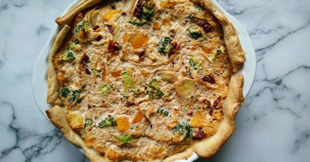 Why are quiches baked in fluted tins? - Quiche Tart on White Ceramic Plate Why are quiches baked in fluted tins? - Quiche Tart on White Ceramic Plate