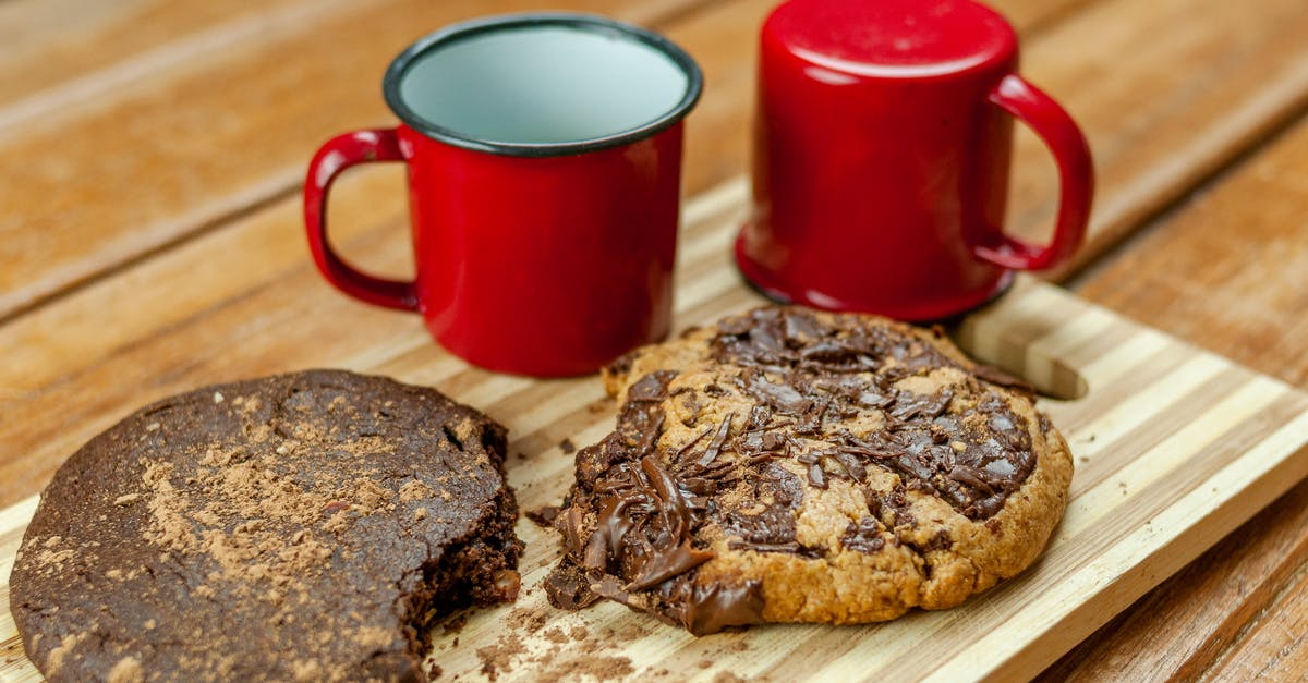 Why are quiches baked in fluted tins? - Delicious chocolate cookies near tin cups prepared for breakfast on wooden striped board on blurred background of table Why are quiches baked in fluted tins? - Delicious chocolate cookies near tin cups prepared for breakfast on wooden striped board on blurred background of table