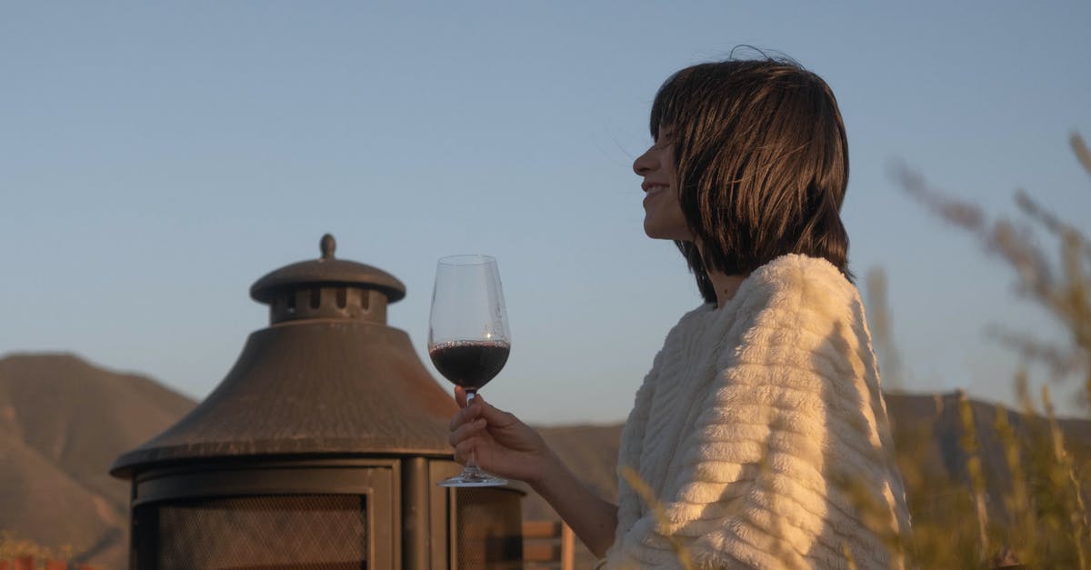 Why are red wine glasses wider than white wine glasses? - Woman Holding Wine Glass Outdoors Why are red wine glasses wider than white wine glasses? - Woman Holding Wine Glass Outdoors