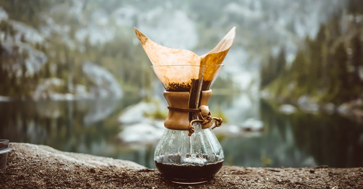 Why brewed coffee in a pot needs a lid? - Chemex pot on rock in mountains Why brewed coffee in a pot needs a lid? - Chemex pot on rock in mountains
