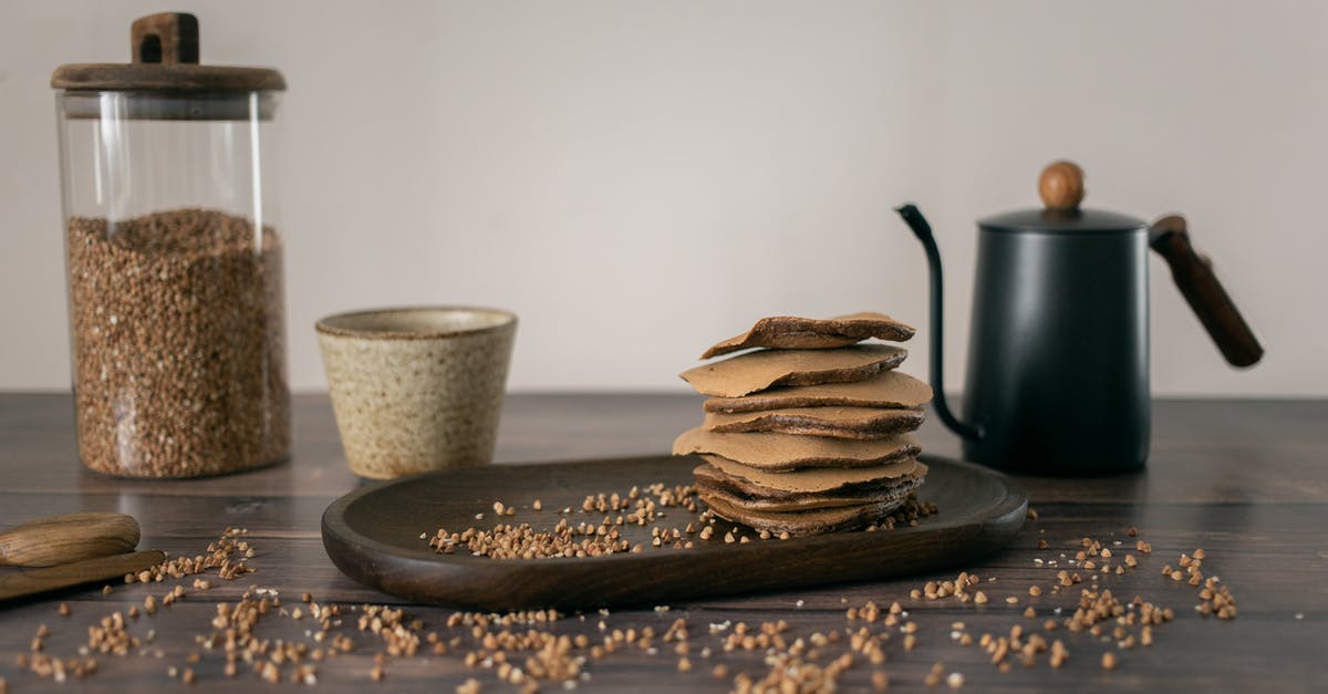 Why Buckwheat Pancakes? - Yummy buckwheat chocolate stuff pancakes served on wooden plate with glass jar of grains and kettle with cup Why Buckwheat Pancakes? - Yummy buckwheat chocolate stuff pancakes served on wooden plate with glass jar of grains and kettle with cup