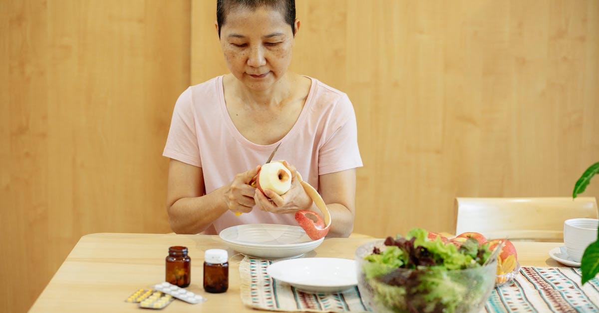 Why can I cook well but not identify flavours? [duplicate] - Middle aged ethnic female with short hair in t shirt peeling fresh apple and preparing salad while sitting at table with veggies and various medicine during remission