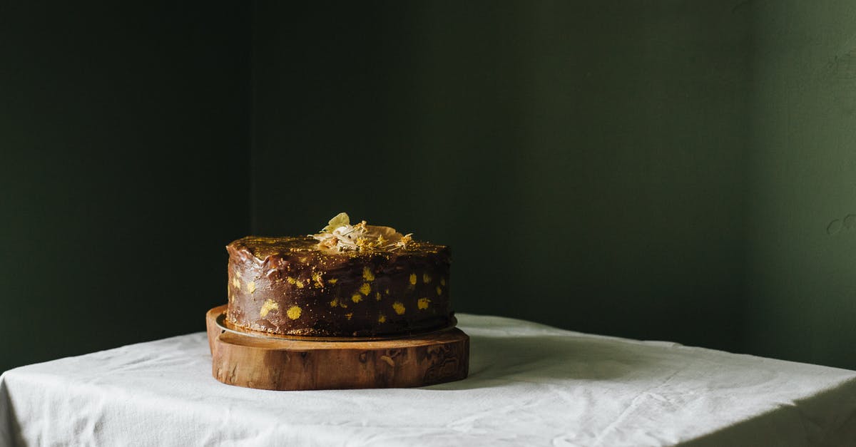 Why did my chocolate icing exude its cocoa butter? - Delicious cake with topping on wooden board Why did my chocolate icing exude its cocoa butter? - Delicious cake with topping on wooden board