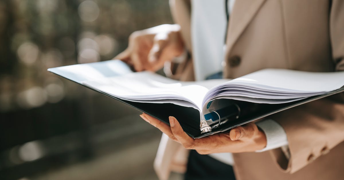 Why do bananas turn black in the refrigerator? - Crop faceless female entrepreneur in formal jacket turning pages of documents in folder while reading Why do bananas turn black in the refrigerator? - Crop faceless female entrepreneur in formal jacket turning pages of documents in folder while reading
