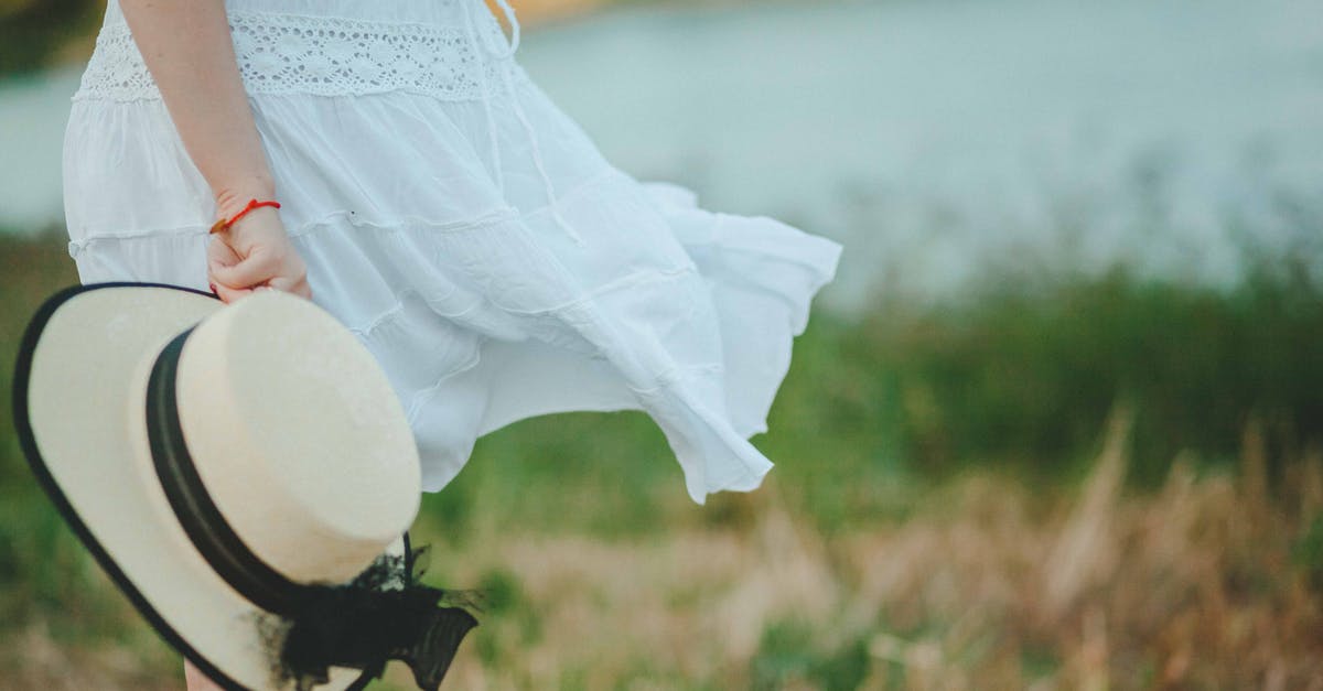 Why do chefs traditionally wear a high white hat? [closed] - Woman in White Dress Holding White and Black Hat at Daytime