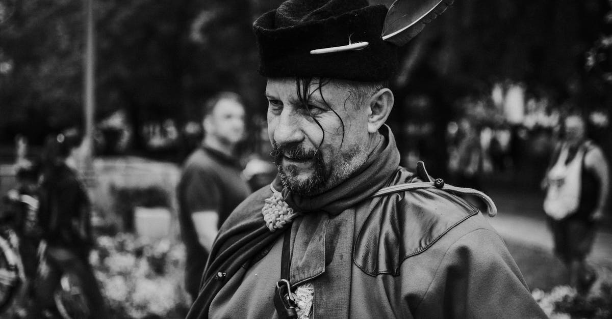 Why do chefs traditionally wear a high white hat? [closed] - Monochrome Photo of Man Wearing Hat With Feather