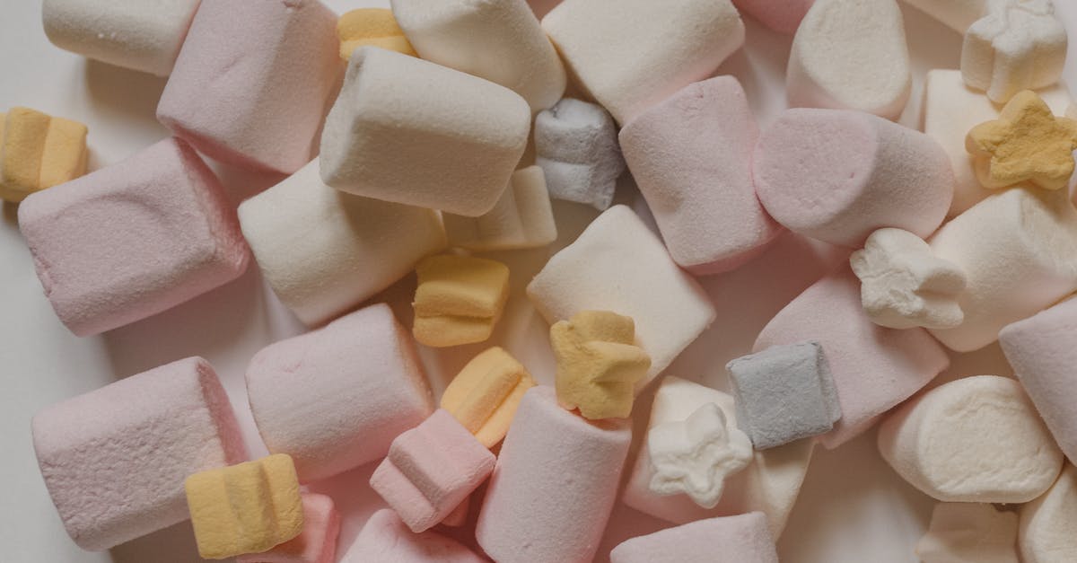 Why do grape-flavored foods taste different than actual grapes? - Top view arrangement of sweet delicious marshmallows of light color heaped on white surface Why do grape-flavored foods taste different than actual grapes? - Top view arrangement of sweet delicious marshmallows of light color heaped on white surface