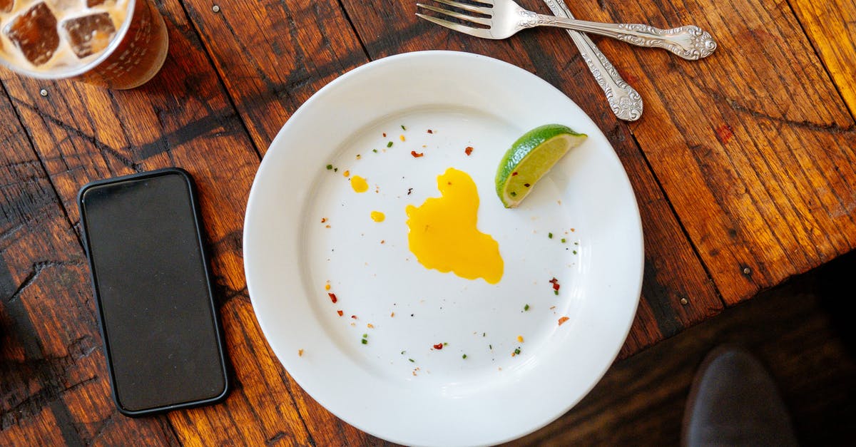 Why do yolks break so easily (sometimes)? - Top view of white plate with slice of lime an egg yolk placed on wooden table near smartphone and iced drink Why do yolks break so easily (sometimes)? - Top view of white plate with slice of lime an egg yolk placed on wooden table near smartphone and iced drink