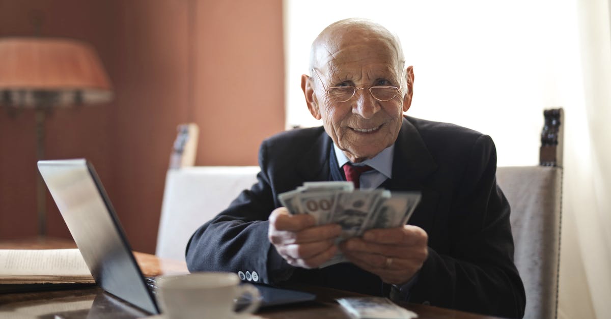 Why do yolks break so easily (sometimes)? - Confident senior businessman holding money in hands while sitting at table near laptop Why do yolks break so easily (sometimes)? - Confident senior businessman holding money in hands while sitting at table near laptop