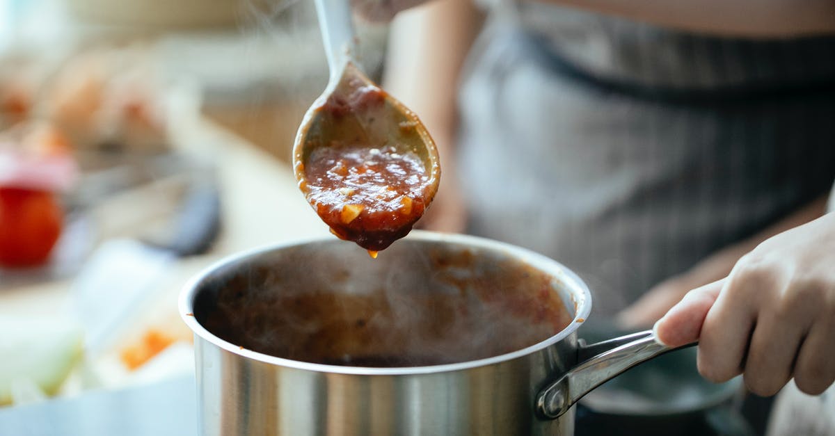 Why do you stir italian sauce all day - Crop women cooking sauce together Why do you stir italian sauce all day - Crop women cooking sauce together