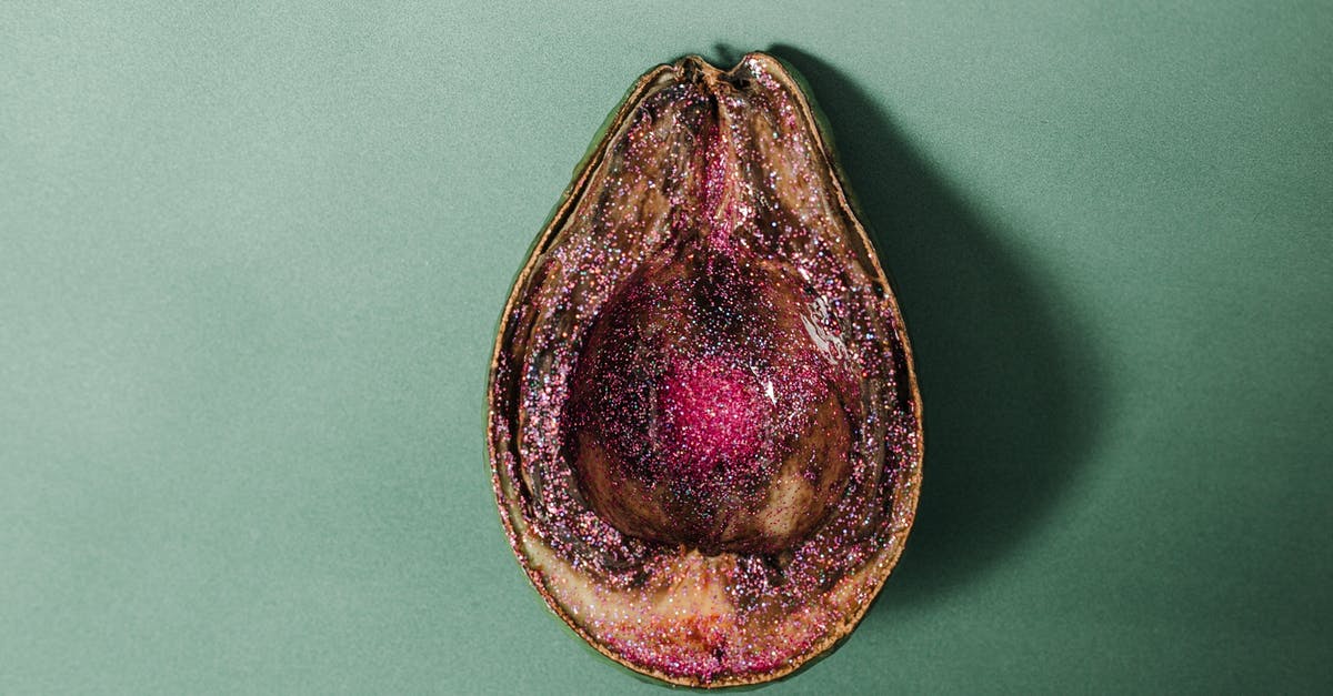 Why does food spoil in the freezer? - From above of half of rotten avocado covered with pink glitter placed on green background in studio Why does food spoil in the freezer? - From above of half of rotten avocado covered with pink glitter placed on green background in studio